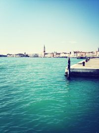 Calm sea against clear blue sky