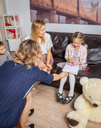 A girl psychologist communicates with the child at a family reception.