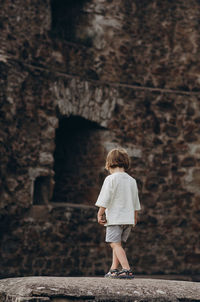 Rear view of boy standing on rock