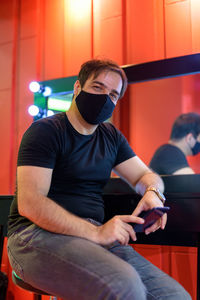 Portrait of man wearing mask sitting at cafe