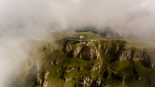 Panoramic view of landscape and mountains against sky with a lonly cable car station