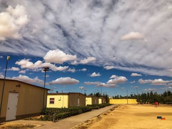 Road amidst buildings against sky