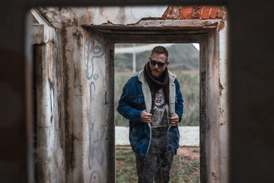 Portrait of a young man standing in abandoned room