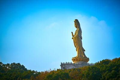 Low angle view of statue against cloudy sky