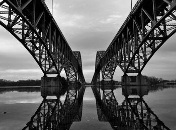 Bridge over river against cloudy sky