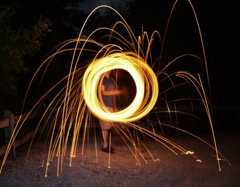 Man spinning wire wool at night