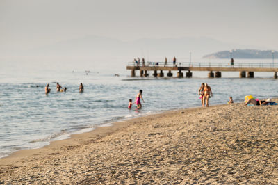 People at beach against sky