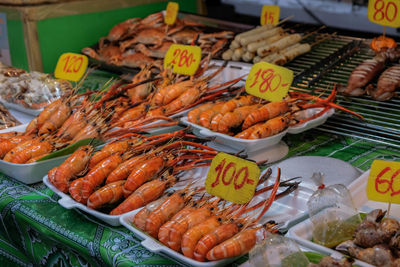 High angle view of seafood with price tags for sale at market stall