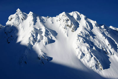 Scenic view of snowcapped mountains against clear blue sky