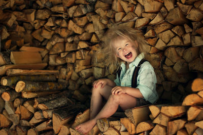 Portrait of smiling boy sitting on logs