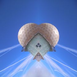 Low angle view of communications tower against blue sky