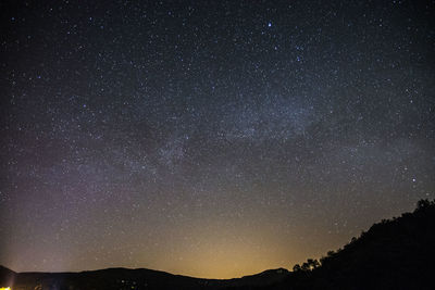 Low angle view of silhouette mountain against sky at night