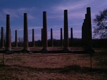 Wooden posts on field against sky