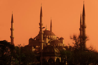 Mosque amidst trees against sky during sunset