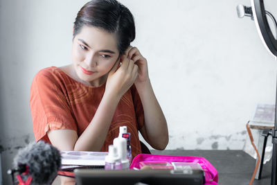 Portrait of young woman sitting on table