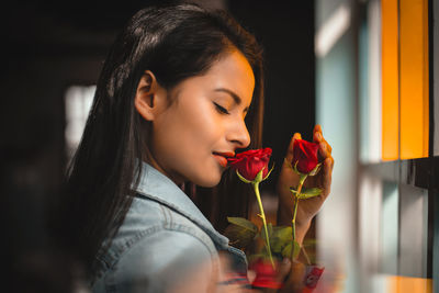 Close-up of woman holding red rose