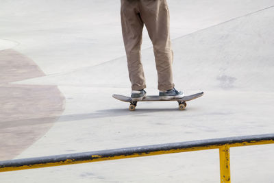 Low section of man skateboarding on footpath