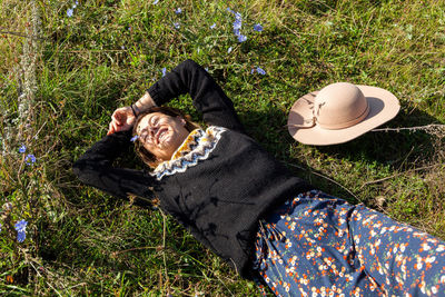 Posing woman in nature. young woman in stylish knitted sweater, hat and dress posing and resting 