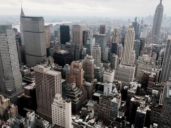 Aerial view of buildings in city against sky