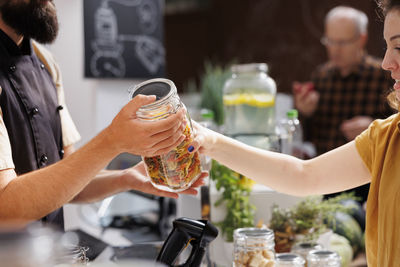 Midsection of woman drinking glass