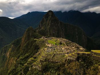 Aerial view of old ruins on mountain against cloudy sky