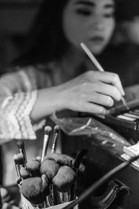 Close-up of woman using make-up brush on table at home