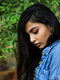 Young woman looking down in park