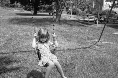 Girl playing on swing in park