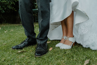 Low section of couple standing on field