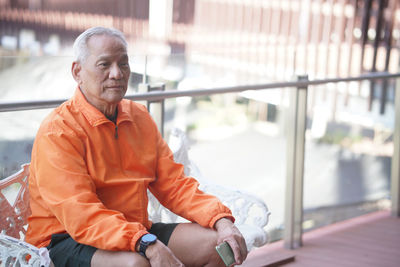 Side view of young man sitting in gym