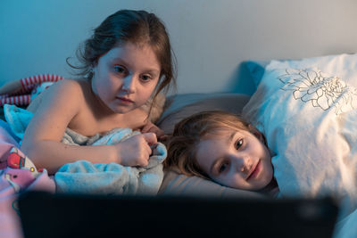 Portrait of women lying down on bed