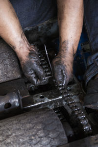 Midsection of man working on metal