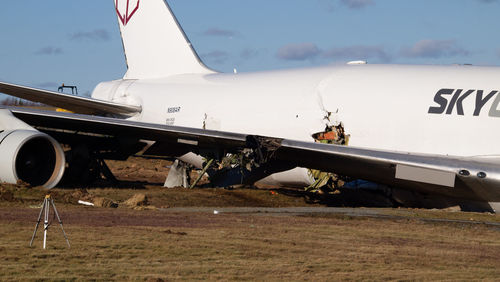 Airplane on airport runway against sky