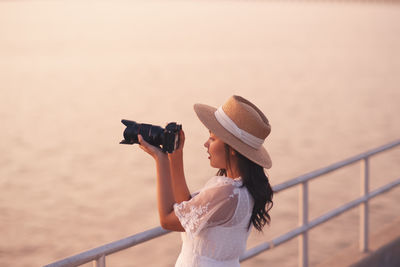 Midsection of woman photographing sea