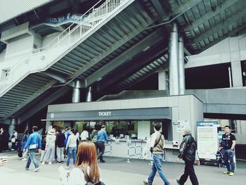 People walking on railroad station platform in city