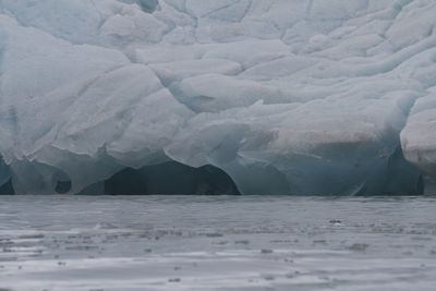 Glacier edge meets the artic ocean with blue ice near svalbard