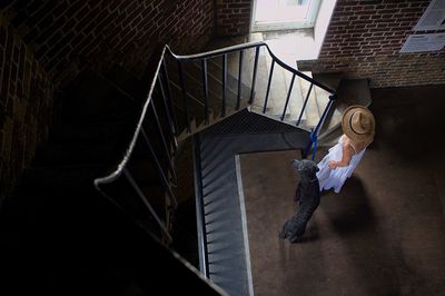 High angle view of woman standing on staircase of building