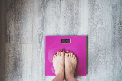 Low section of woman standing against wall