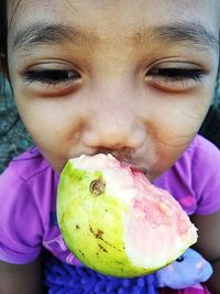 Close-up of girl eating guava