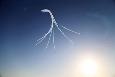 Low angle view of airplane flying against clear blue sky