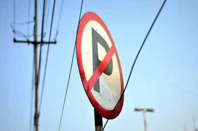 Close-up of no parking sign against sky