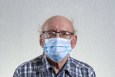 Portrait of man wearing mask against white background
