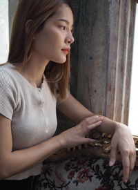 Young woman looking away at home