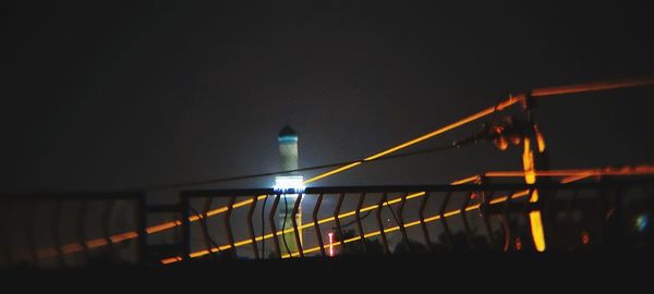 Illuminated bridge against sky at night