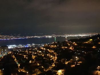 Illuminated cityscape against sky at night