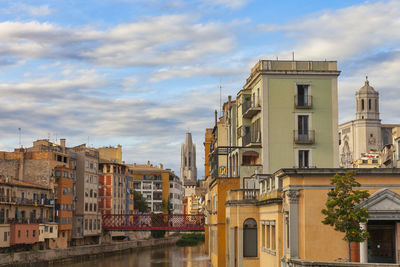 Buildings in city against cloudy sky