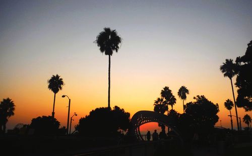 Silhouette of palm trees against sky during sunset