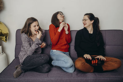 Young woman sitting on sofa at home