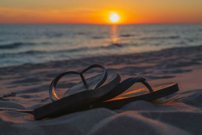 Close-up of sunglasses on beach during sunset