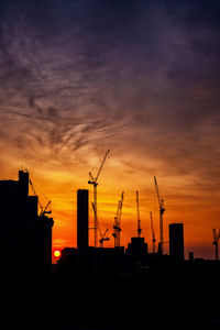 Silhouette buildings against sky during sunset